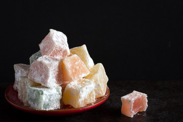 Close up of Turkish Delight on a Plate Front View on Dark Background with Copy Space