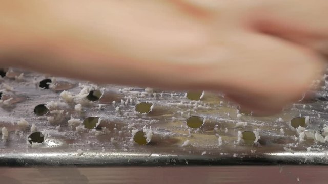 Cheese grater preparing parmesan for pizza in 4K 3840X2160 UHD video - Cheese grating close up shoot in 4K 2160p UHD footage 