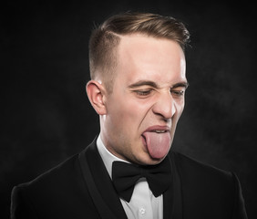 Businessman in suit shows tongue.