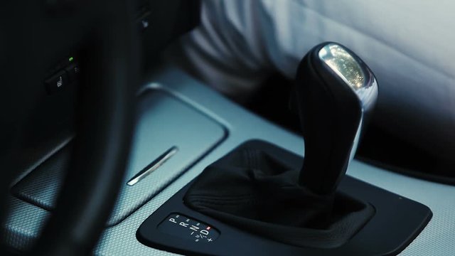 Woman hand switching gear stick in car. Driver. Transport. Close up