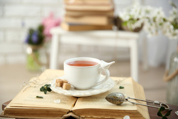 Open book and cup of tea wooden table