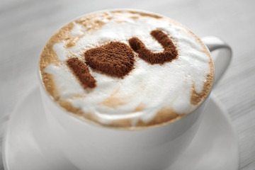 Cup of coffee with creative pattern on wooden table