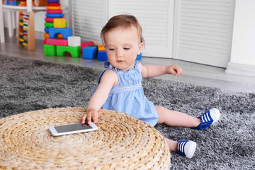 Naklejka premium Little girl with telephone on carpet
