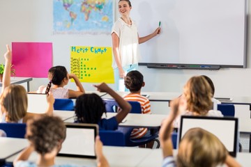 Teacher teaching students using whiteboard