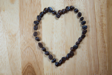 Coffee beans make into Heart shape on wood background