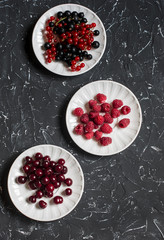 Assortment of summer berries - cherries, raspberries, red and black currant on a dark background
