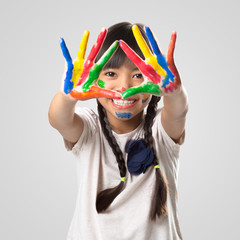 Little asian girl with her hands in the paint, Isolated over white