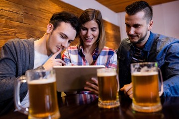 Friends using digital tablet at restaurant