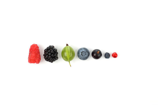 different juicy berries laid out in a row on white background