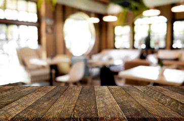 Selected focus empty brown wooden table and Coffee shop blur bac