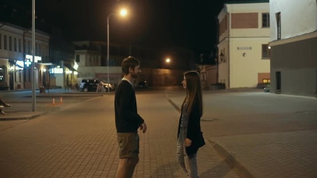 Happy couple meeting on the street at night