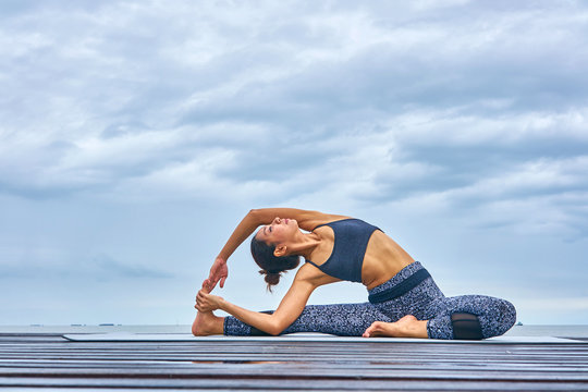 Thai woman professional yoga trainer poses in outdoor location in Thailand.