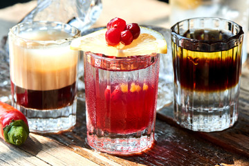 Set of alcoholic cocktail consisting of B-52, the pupil of a Nazi and boyarsky in glasses on a wooden table