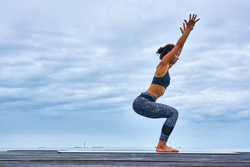 Thai woman professional yoga trainer poses in outdoor location in Thailand.