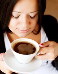 young woman sitting in a cafe drinking coffee