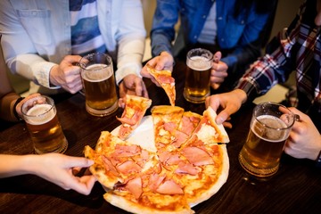 Friends with beer mug and pizza in bar