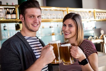 Portrait of couple toasting beer mug 