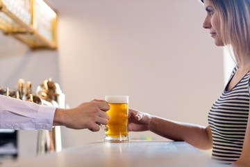 Bartender serving beer to female customer