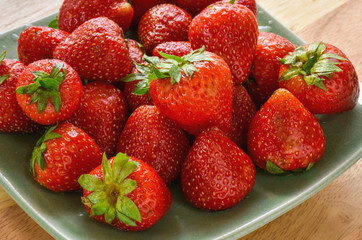 Ripe strawberry in a ceramic dish ready to eat as dessert or prepare for jam.