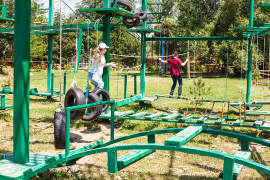two girls pass an outdoor obstacle course