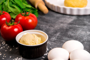 Vegetables and dough over grey wooden background