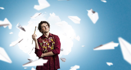 Man artist painting with brush . Mixed media