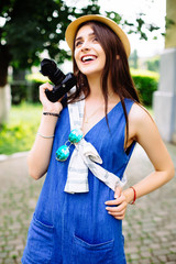 Outdoor summer smiling  young girl having fun in the city with camera travel photo of photographer Making pictures