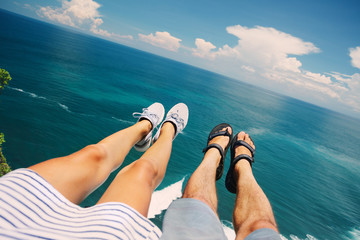 Couple sitting above the ocean - obrazy, fototapety, plakaty