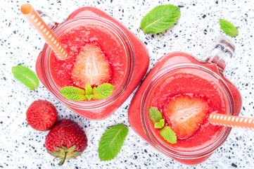 Summer drink coctail strawberry smoothies in glass jar, berries and mint on white background. Healthy food