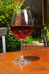 Glass of wine on wooden terrace table