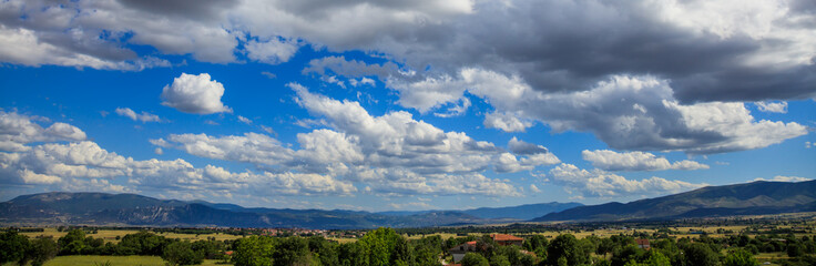Obraz na płótnie Canvas Scenic rural background with blue sky and white fluffy clouds