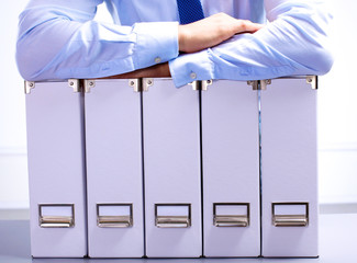 businessman standing over a folder with documents