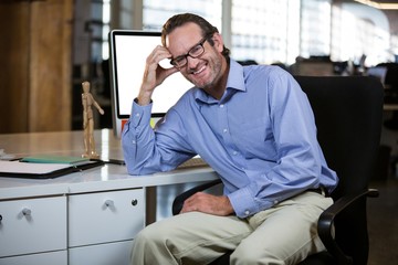 Creative businessman leaning at computer desk 