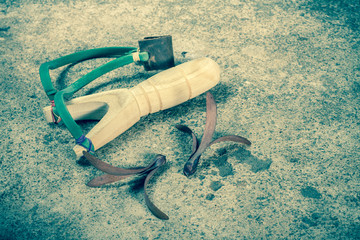Wooden catapult slingshot with seed plant on cement background