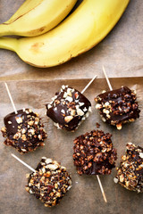 Frozen banana covered with chocolate and peanuts