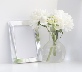 Bouquet of white peonies and silver frame