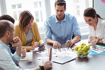 Editors with documents working in meeting room