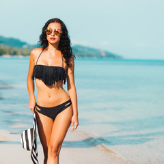Freedom woman in free happiness bliss on beach. Smiling happy multicultural female model in white cool black bikini enjoying serene ocean nature during travel holidays vacation outdoors.