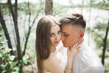 Fototapeta premium Wedding couple man, bride kissing and hugging on a background of the river, mountains. Beauty portrait