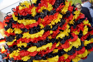 Row of chaplets (small wreaths) in the German national colors of black, red and yellow in the fan store selling the goods for supporters of the German national football team