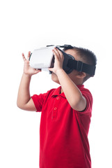 Amazed little asian boy looking in a VR goggles and gesturing wi