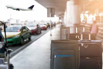 Closeup of group of luggage with the blurred of the taxi park at the airport terminal background.