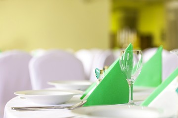 Wasserglas und Servietten auf gedecktem Tisch