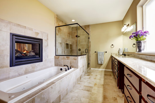 Master bathroom in modern house with fireplace and tile floor