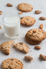 Cookies pile with chocolate chip and almond on light textile background. Delicious morning snacks for breakfast, brunch and lunch. Appetizing, healthy and fast food

