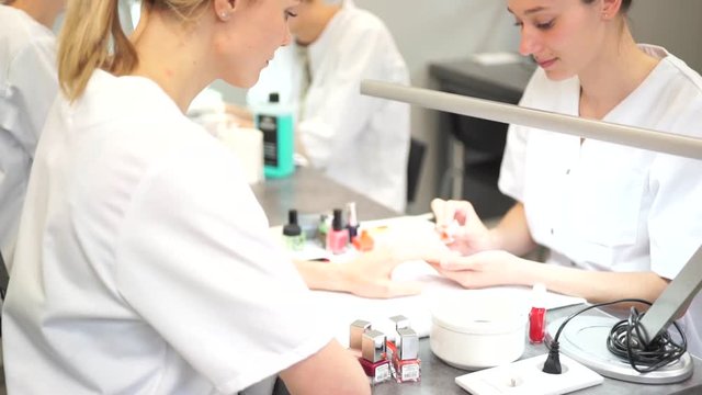 View of a Young attractive beautician students practising during courses