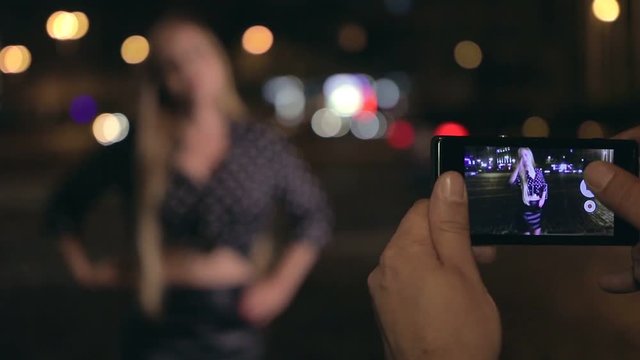 Young man makes photos of his girlfriend at night