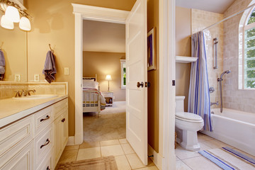 Bright bedroom with colorful curtain, beige walls and tile floor