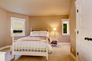 Simple beige bedroom interior with carpet floor and two windows.