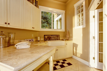 Bright kitchen room area with white cabinets, granite counter top and tile floor